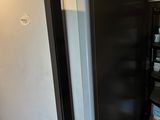 a refrigerator that is in the corner of a room
