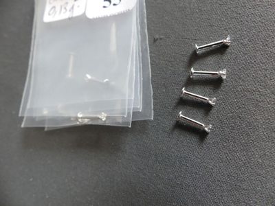 four screws in a plastic bag on a table