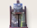 une étagère en bois sur laquelle sont posés trois tableaux