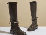 un gros plan sur une paire de bottes marron posées sur une surface blanche