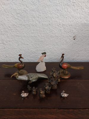 plusieurs figurines posées sur une table en bois, avec un mur blanc en arrière-plan