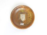 a brown plate with a face on it on a white surface