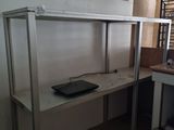 un bureau sur lequel se trouve un ordinateur portable, dans un coin de la pièce