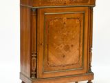 a small wooden cabinet with carvings on the front
