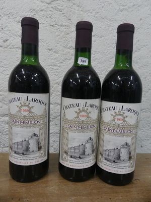 trois bouteilles de vin posées sur une table en bois