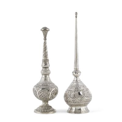 deux vases en argent posés l'un à côté de l'autre sur une surface blanche