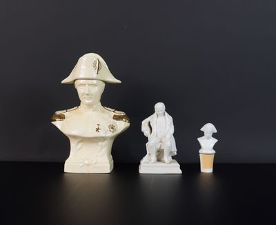 deux bustes d'hommes blancs et une statue d'homme posée sur une table