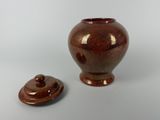 a brown vase with a lid sitting on a table