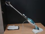 someone is using a steam mop to clean a wooden table