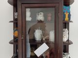 une étagère en bois avec une porte vitrée et une horloge posée dessus