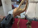 a gold flamingo statue on a red table with a lamp on it
