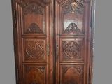 une photo d'une armoire en bois dont les portes sont ornées de sculptures