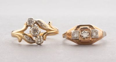 two gold rings with diamonds on them sitting on a table
