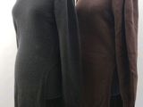two sweaters on a mannequin stand in front of a white background