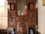 a wooden cabinet with a mirror on it in the corner of a room