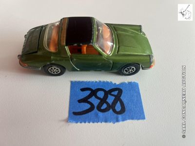une petite voiture verte posée sur une feuille de papier