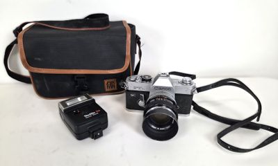 a camera, flash and a camera case on a table