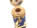 a blue and gold vase with a gold lid on it