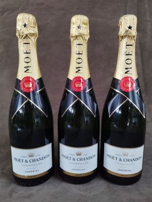 trois bouteilles de champagne Moët & Chandon sur fond gris