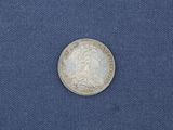 a close up of a silver coin on a blue cloth