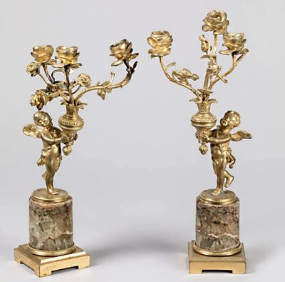 paire de bougeoirs anciens en laiton, ornés de chérubins et de fleurs, sur des socles en marbre