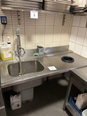 a kitchen with a sink, stove, and other items on the counter