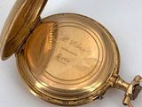 a gold pocket watch on a white surface
