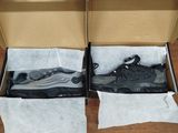 pair of black and white sneakers in a box on a wooden floor