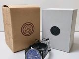 une montre posée à côté d'une boîte sur une table