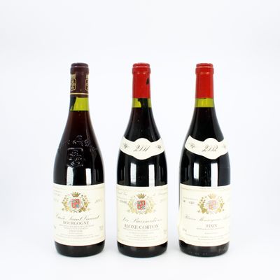 three bottles of wine are lined up on a white surface