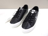 black leather sneakers with white soles on a white surface