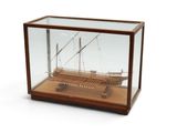 une maquette en bois d'un bateau exposée dans une vitrine