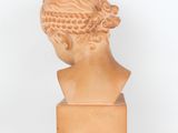 sculpture of a woman ' s head with braids on a wooden base