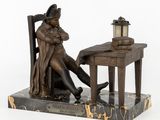 statue of a man sitting at a desk with a lamp on top of it
