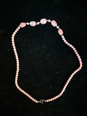 a pink beaded necklace with a heart charm