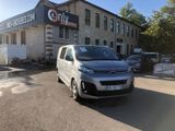 a silver van parked in front of a building with a sign on it