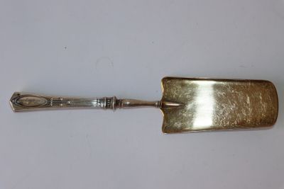 une cuillère en argent avec un manche sur une surface blanche