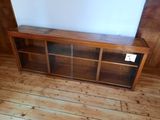a wooden entertainment center with glass doors on the sides