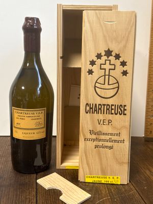 une bouteille de vin à côté d'une caisse en bois sur une table