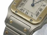 a silver and gold wrist watch with roman numerals on it