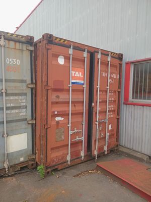two shipping containers sitting next to each other outside a building