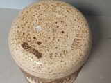 a brown and white vase sitting on a table