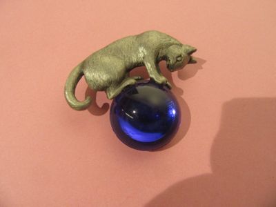une figurine représentant un chat posé sur une balle bleue