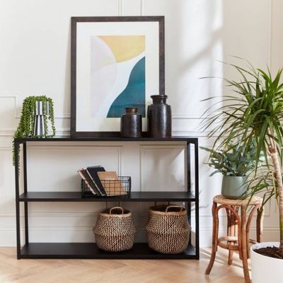 an image of a living room with a plant and a picture on the wall