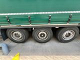 a green truck that is parked on the side of the road