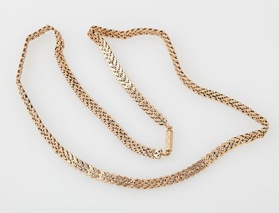 a close up of a gold chain on a white surface