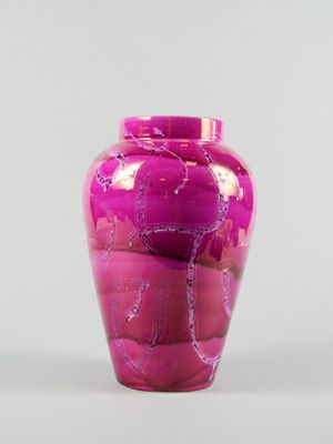 un vase rose posé sur une table