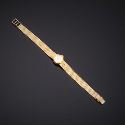 une montre en or avec un cadran blanc sur fond noir