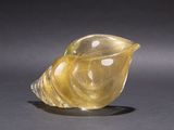 an image of a yellow glass shell on a black surface