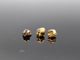 a pair of gold earrings on a reflective surface